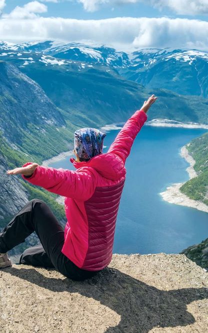 fjord norway woman sitting on edge of trolltunga istk