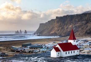 iceland vik i myrdal church with reynisdrangar in background istk