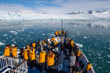 arctic admiring svalbard scenery from ship bow qe