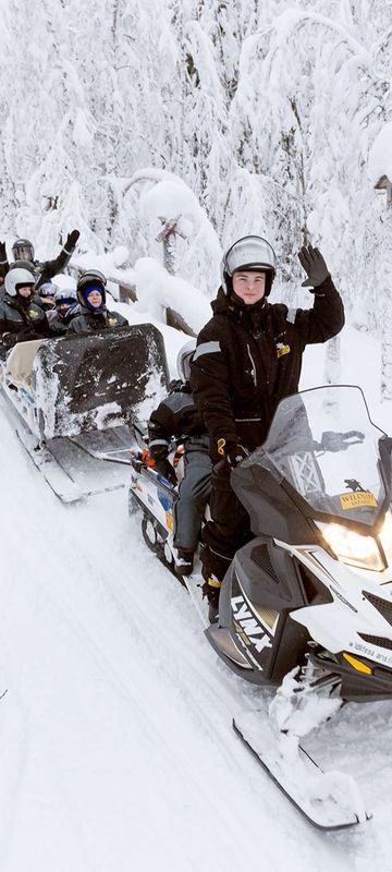 finnish lapland ranua snowmobiling with children on sled