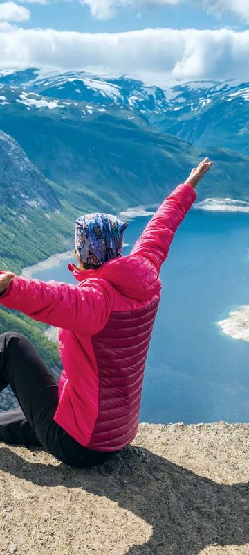 fjord norway woman sitting on edge of trolltunga istk