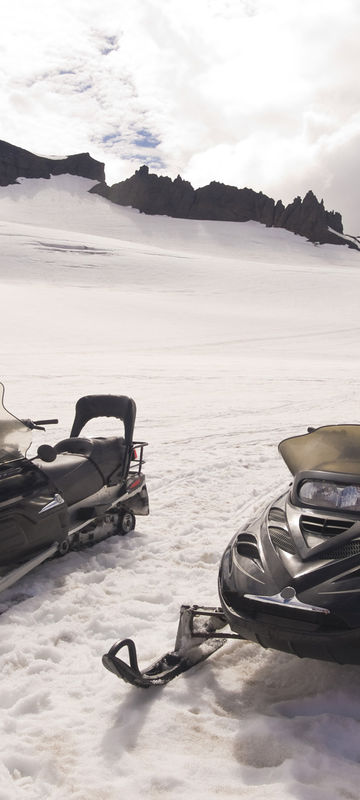 south iceland snowmobiles awaiting drivers on glacier istk