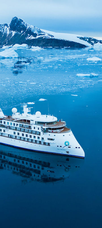 Aerial view of The Greg Mortimer expedition ship sailing in Antarctica