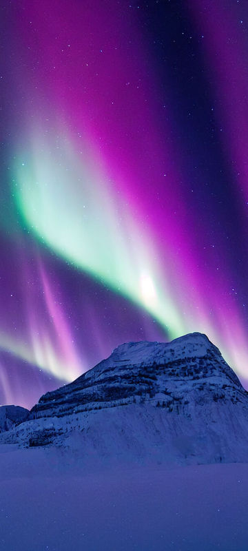 Green and purple aurora light the sky in Lapland