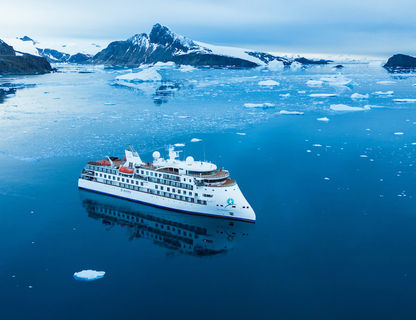 Aerial view of The Greg Mortimer expedition ship sailing in Antarctica
