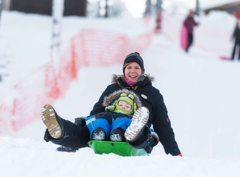 finnish lapland nellim adult child on toboggan