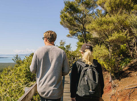 rangitoto volcanic island tour couple walking up broadwalk to volcano top