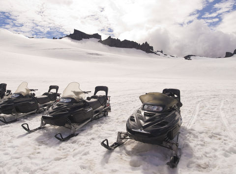 south iceland snowmobiles awaiting drivers on glacier istk